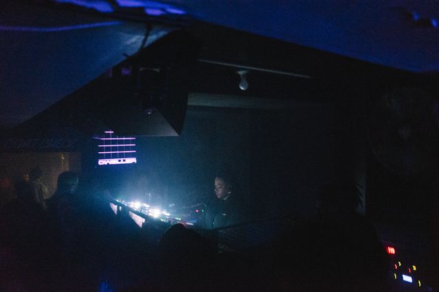 Photograph of a DJ performing in a crowded nightclub